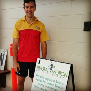 Photo of man with red and yellow shirt standing next to Pivotal Motion sign