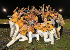 Group photo with men in yellow shirts holding trophy