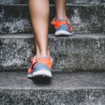 Photo of a person in sports shoes climbing stairs | Featured Image for Treating Ankle Sprains blog for Pivotal Motion Physiotherapy.