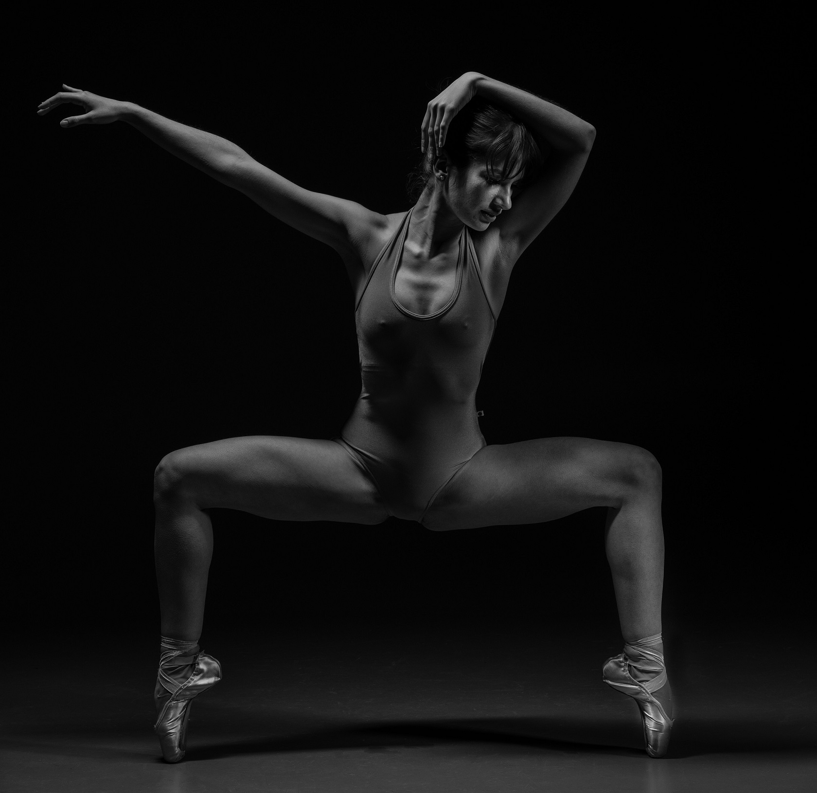 Black and white photo of a ballet dancer posing | featured image for Everybody Dance Now blog from Pivotal Motion Physiotherapy.