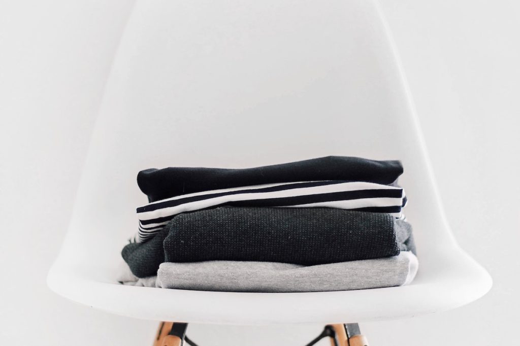 Pile of winter clothes on chair | featured image for Seven Ways to Warm Up this Brisbane Winter.