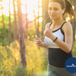 Woman running in a forest | Featured image for Why Trail Running is a Workout in Itself blog for Pivotal Motion Physiotherapy.