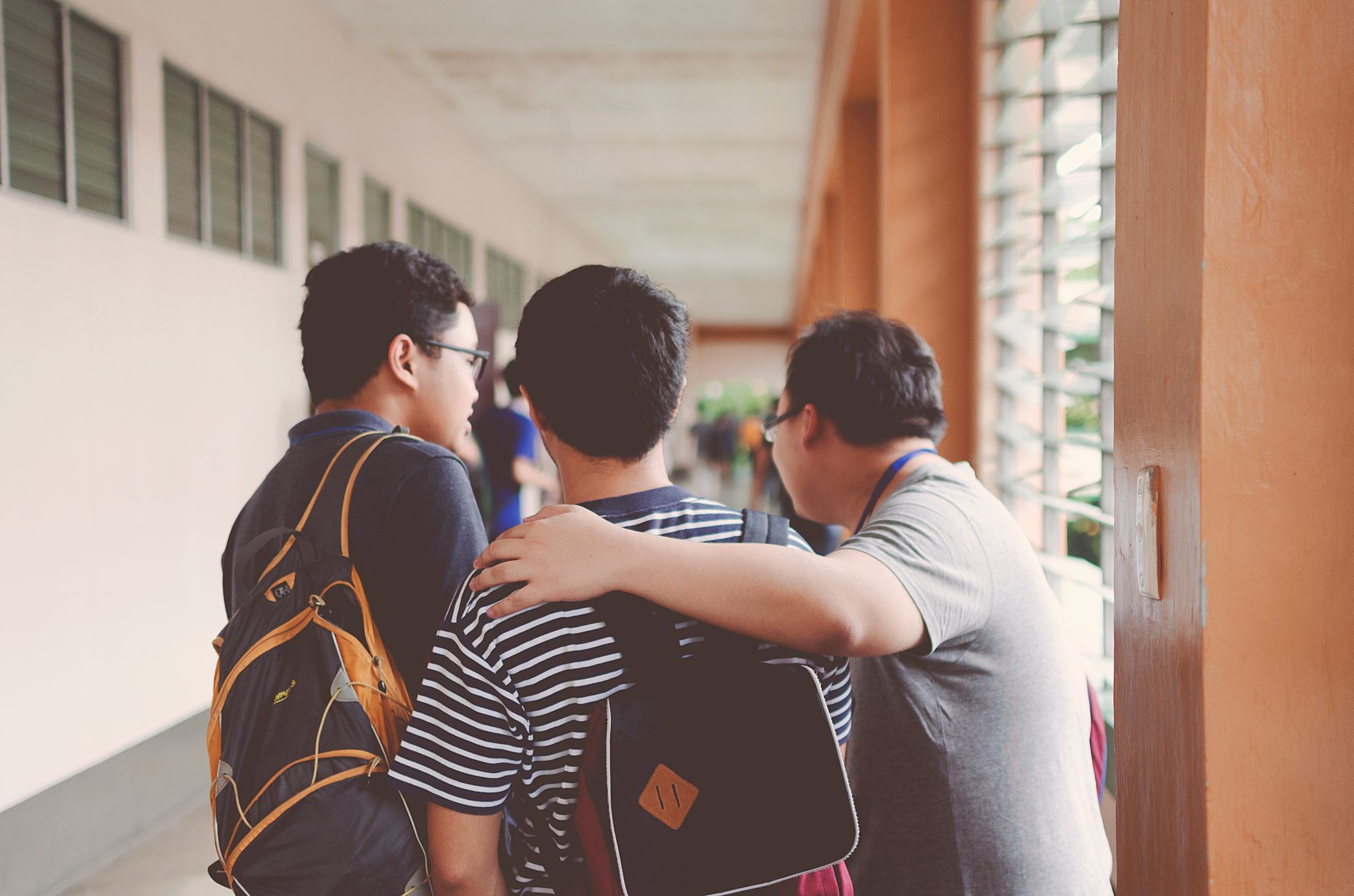 Group of teens in a school hallway | Featured image for Teens and Weight Lifting blog for Pivotal Motion Physiotherapy.