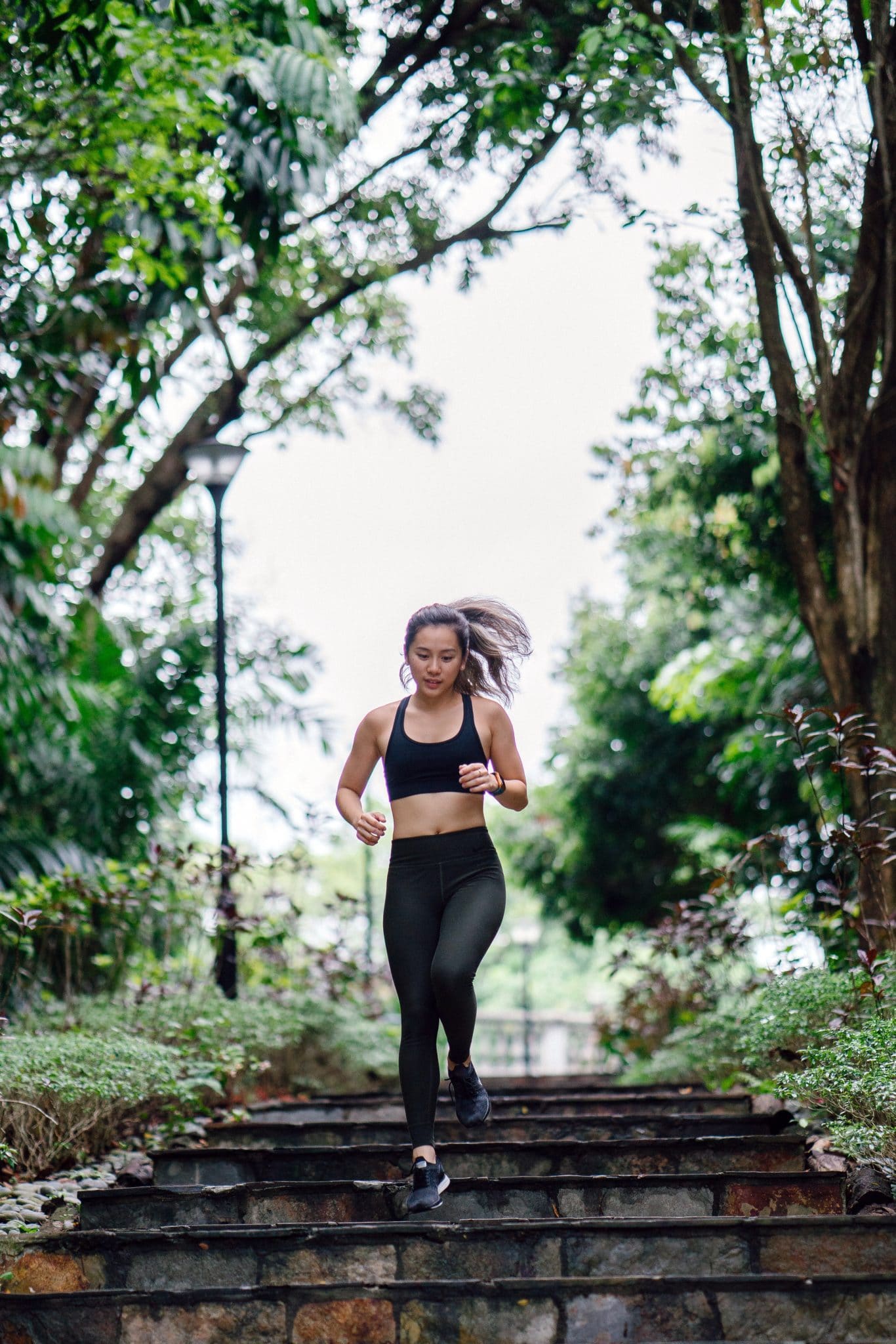 Woman running down stairs | Featured image for The Difference Between Road and Trail Shoes blog for Pivotal Motion Physiotherapy.