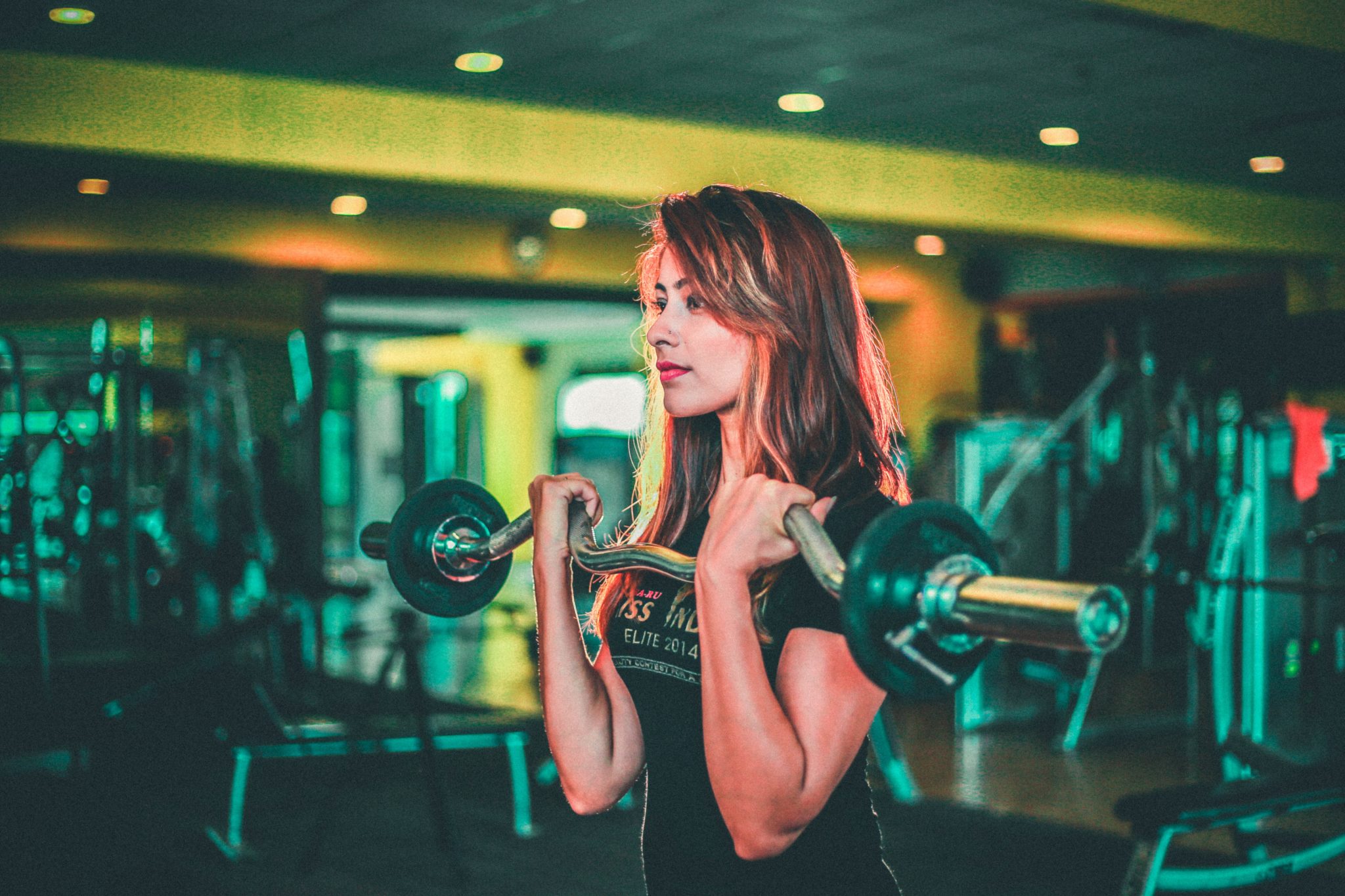 Woman doing weighted bar exercises.