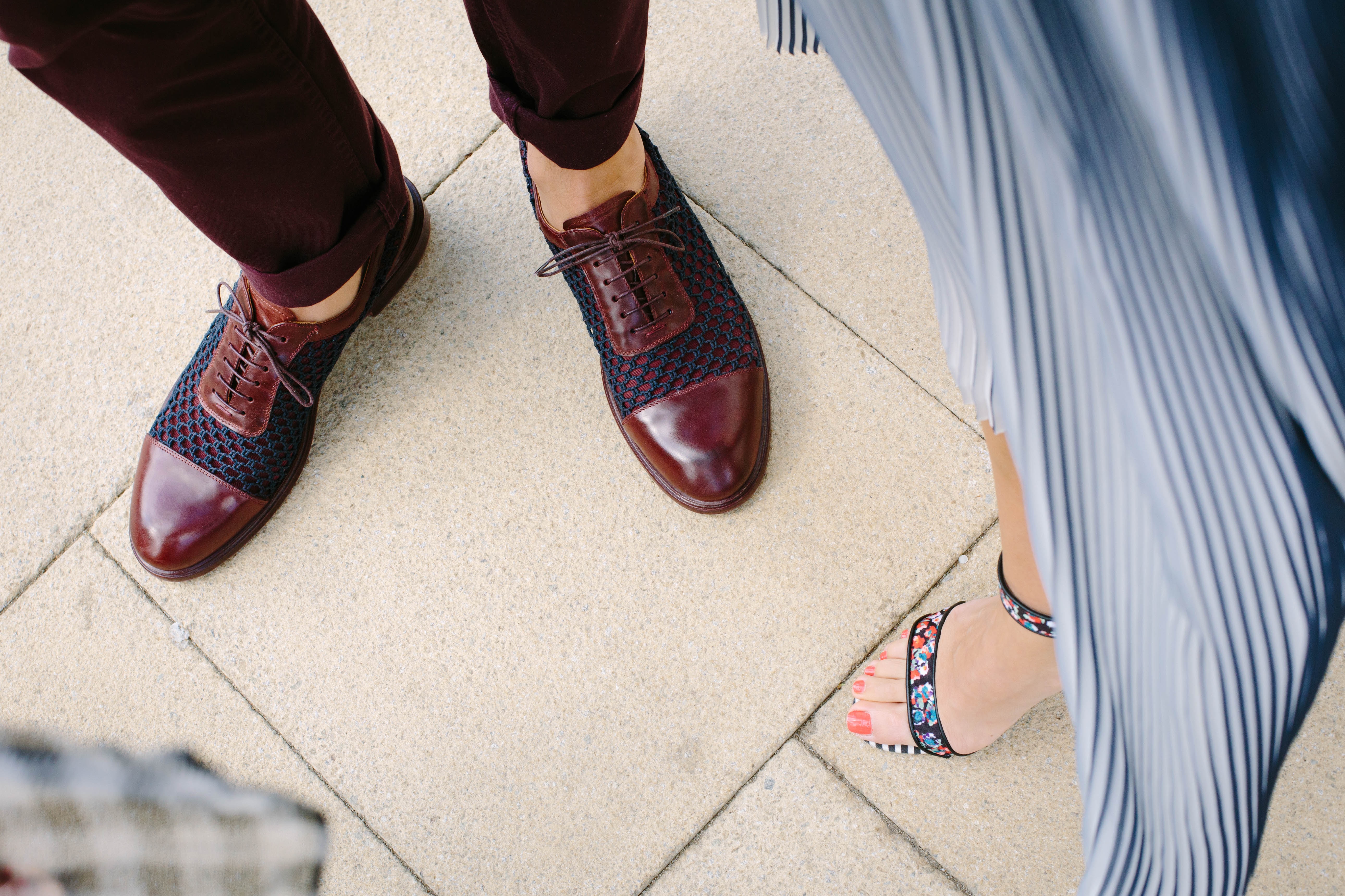 Image of person wearing burgundy shoes and woman wearing patterned heels.