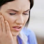 Woman with jaw pain | Featured image for Jaw Physiotherapy Treatment service at Pivotal Motion.