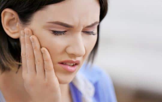 Woman with jaw pain | Featured image for Jaw Physiotherapy Treatment service at Pivotal Motion.