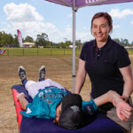 Bobbie performing massage on a baseball player | Featured image for Massage Recovery and Easy Weeks Can Boost Performance Improvements blog for Pivotal Motion Physiotherapy.