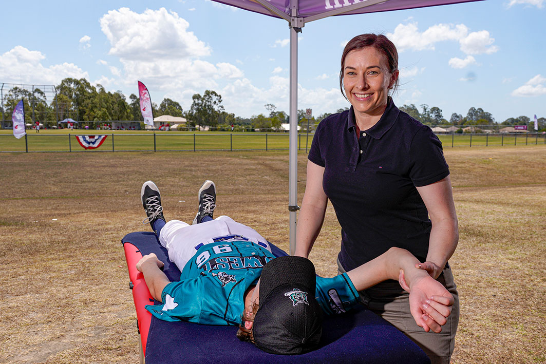 Bobbie performing massage on a baseball player | Featured image for Massage Recovery and Easy Weeks Can Boost Performance Improvements blog for Pivotal Motion Physiotherapy.