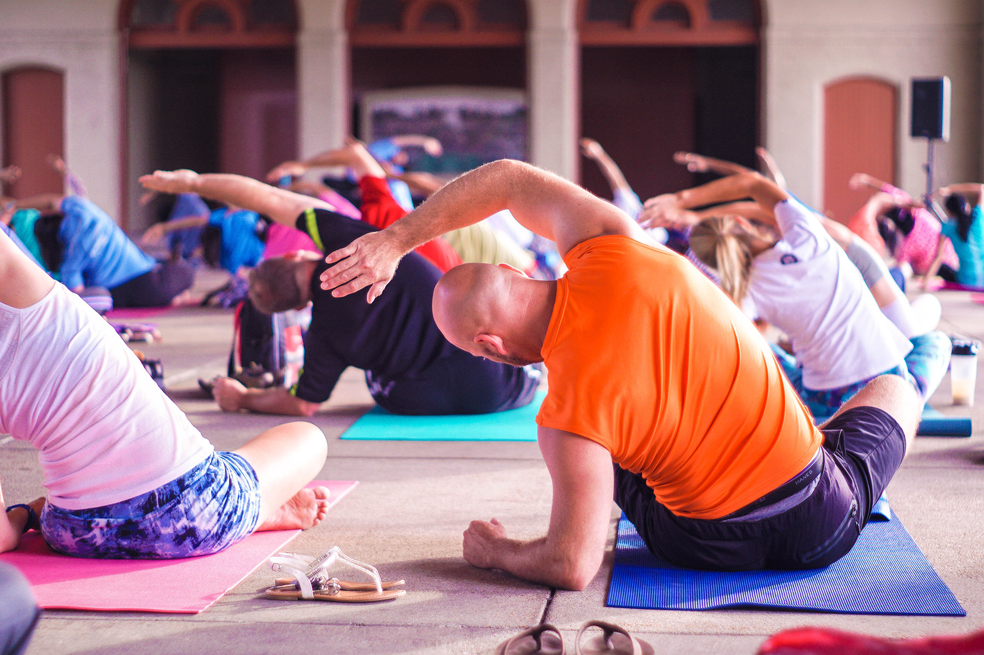 Group of people doing yoga stretches in unison