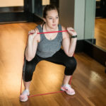 Woman does a squat exercise | Featured image for correct knee posture article.