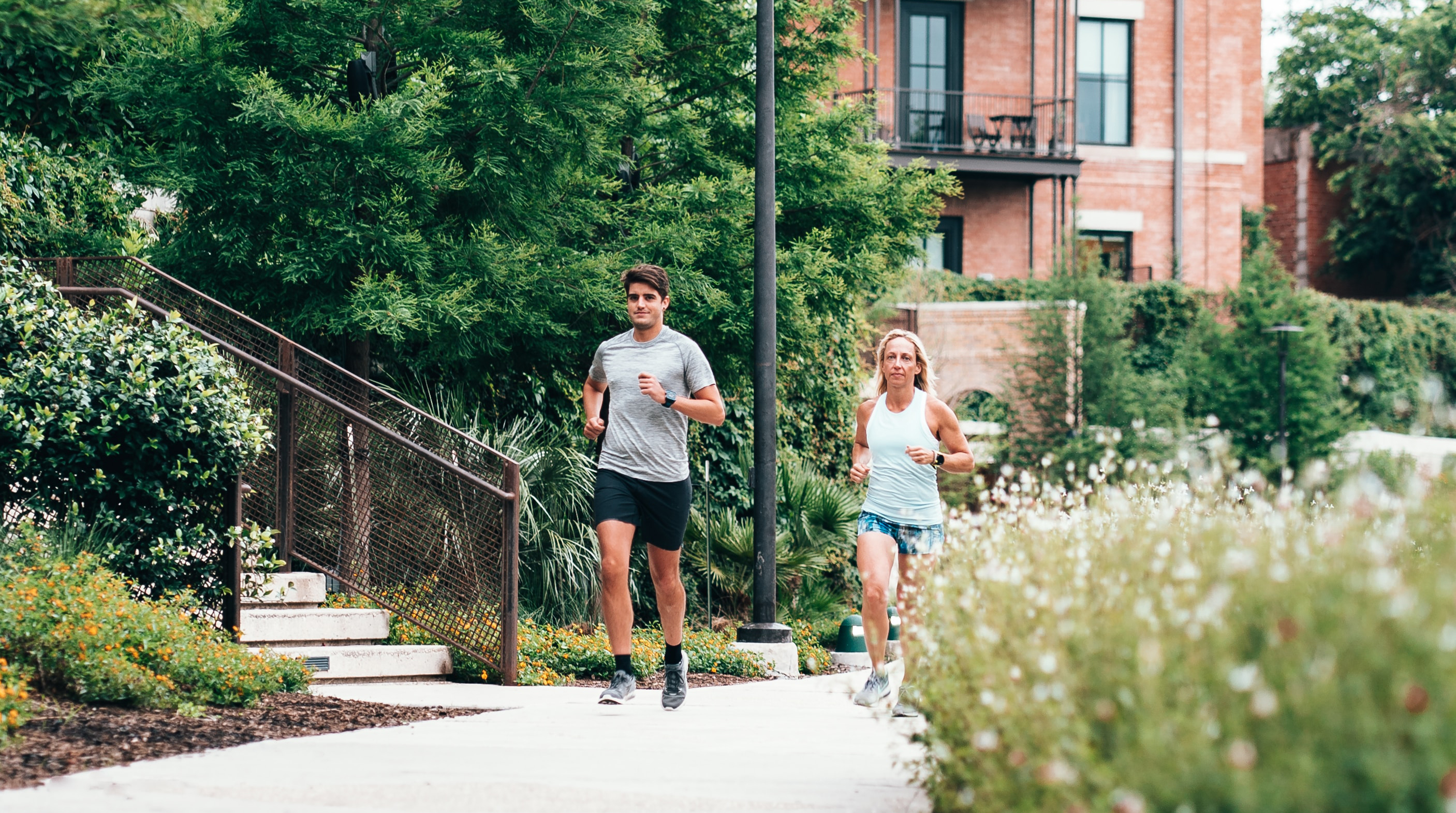 A man and woman running through an inner city suburb