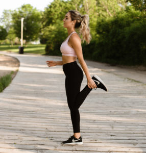 Woman stretching her hamstring for hamstring strain prevention.