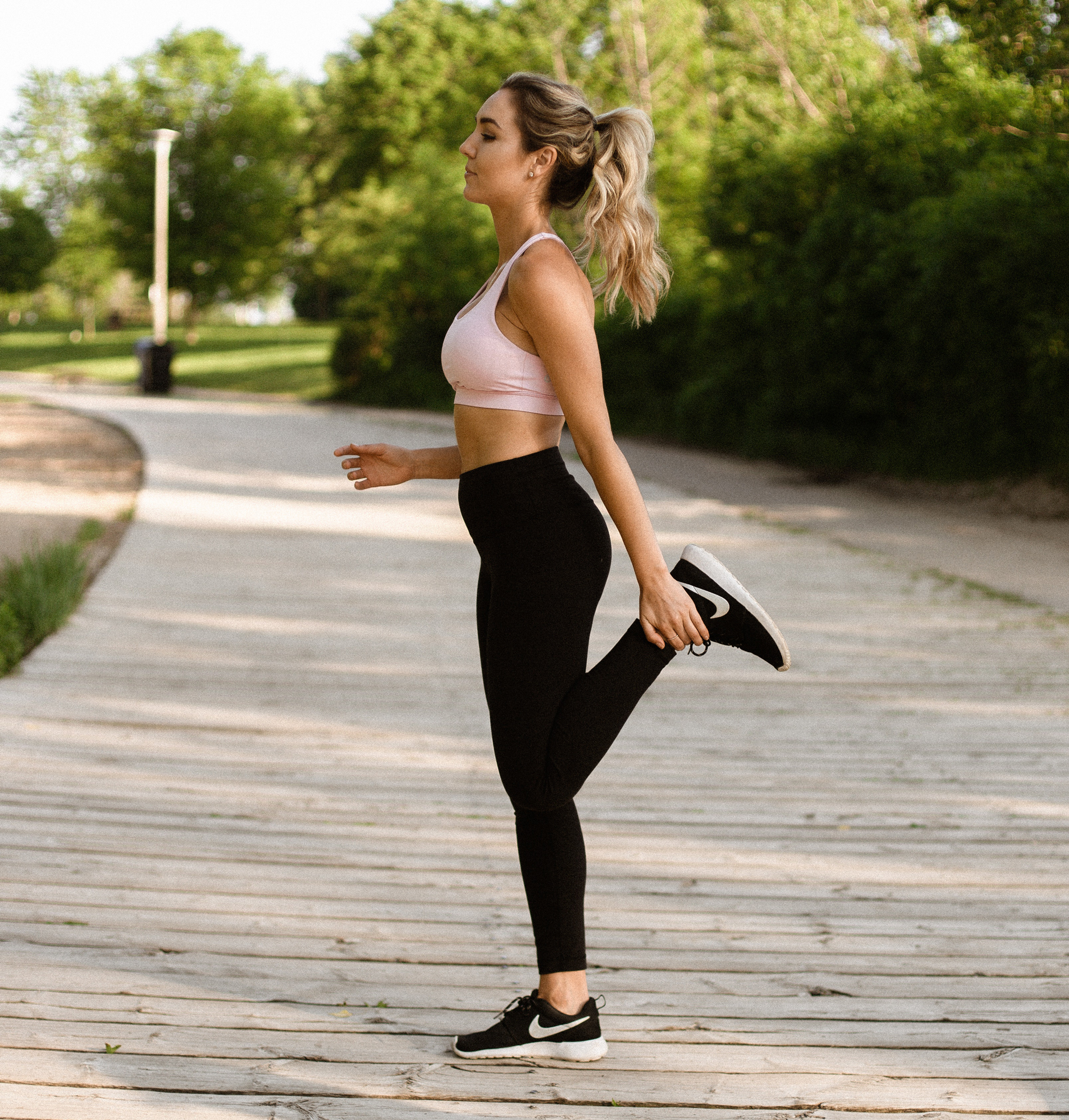 A woman stretching her hamstring for hamstring strain prevention.