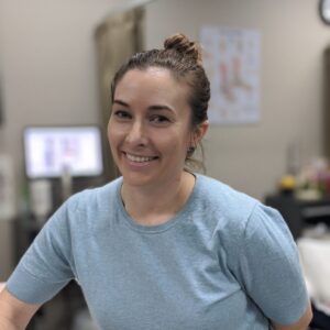 Image of woman with bun and light blue shirt smiling