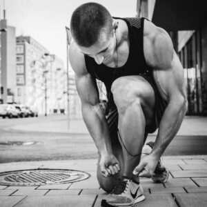 Man leaning down tying shoelaces