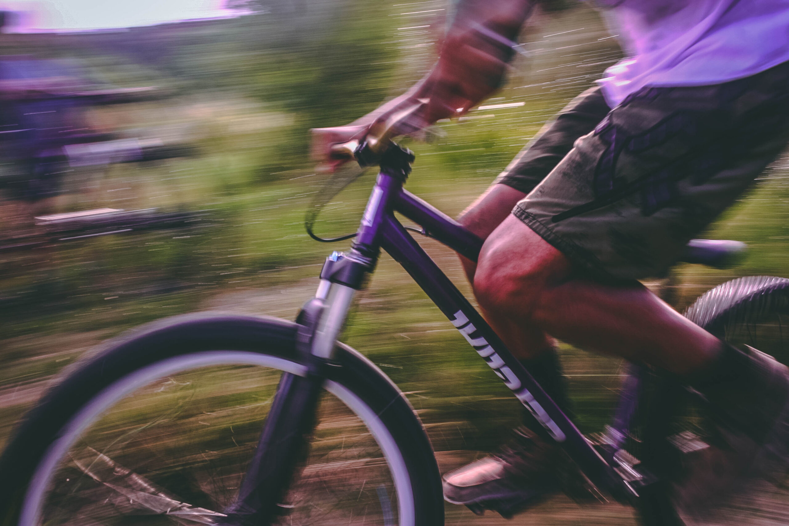 Guy riding a bike in grassland | Featured image for Understanding the Importance of Exercise in Adolescence blog for Pivotal Motion Physiotherapy.