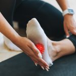The trainer massages female feet with spiked ball, prevention of flat feet | | Featured Image for Identifying Flat Feet and Ankle Pronation | Blog