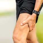 A close up of a man holding the back of his thigh | Featured image on Hamstring Injury.