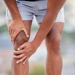 Man grabbing knee | Featured Image for the Osteoarthritis Exercises page by Pivotal Motion Physiotherapy