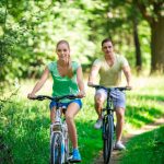 Couple riding a bike | Featured Image for the Exercise and Mental Health Page by Pivotal Motion Physiotherapy