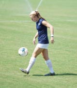 Woman kicking a soccr ball | Featured image for the Sprained Ankle Treatment page of Pivotal Motion.