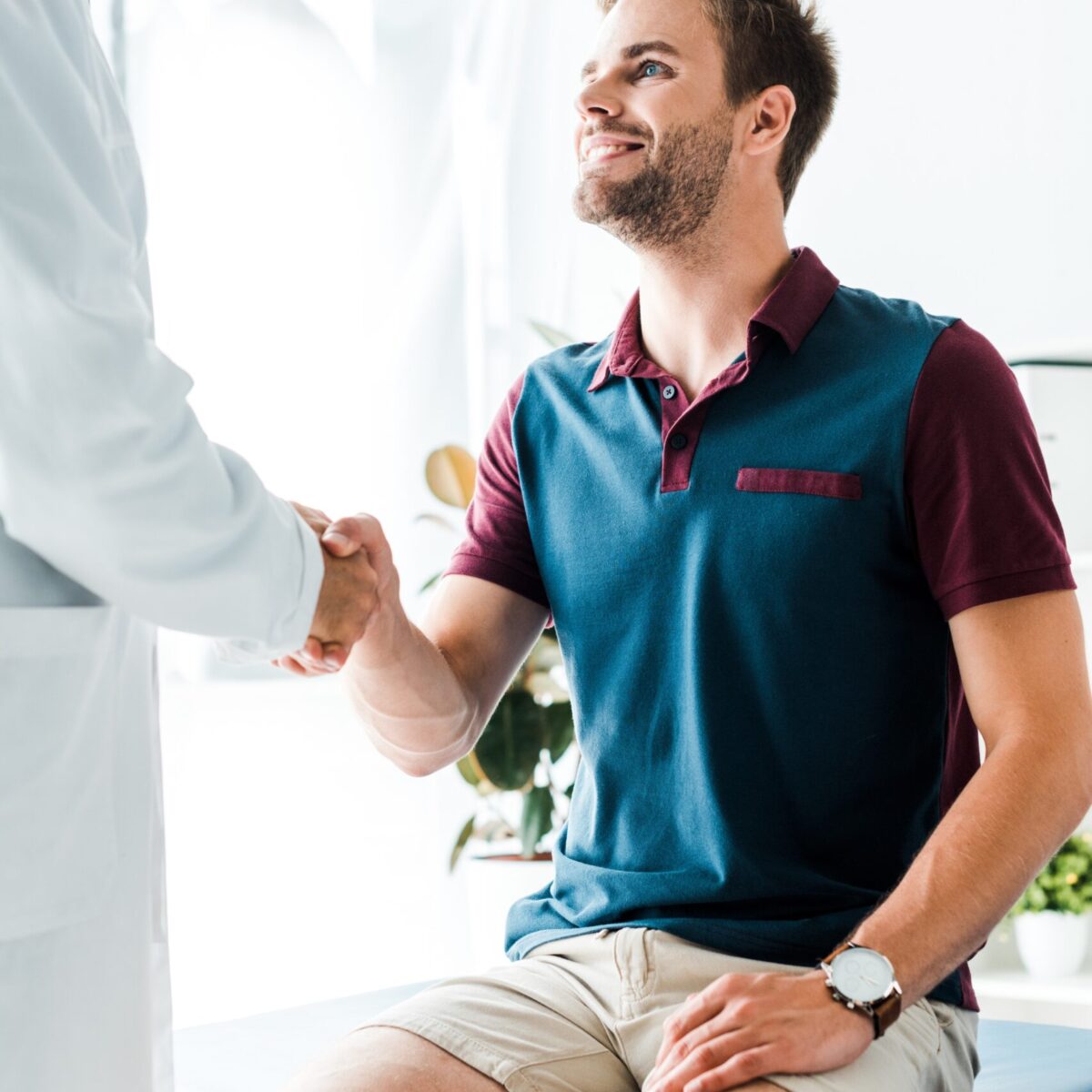 pre-employment-physio-assessment Happy patient shaking hands with bearded physio in white coat | Featured Image for the Pre-Employment Physio Assessment service landing page